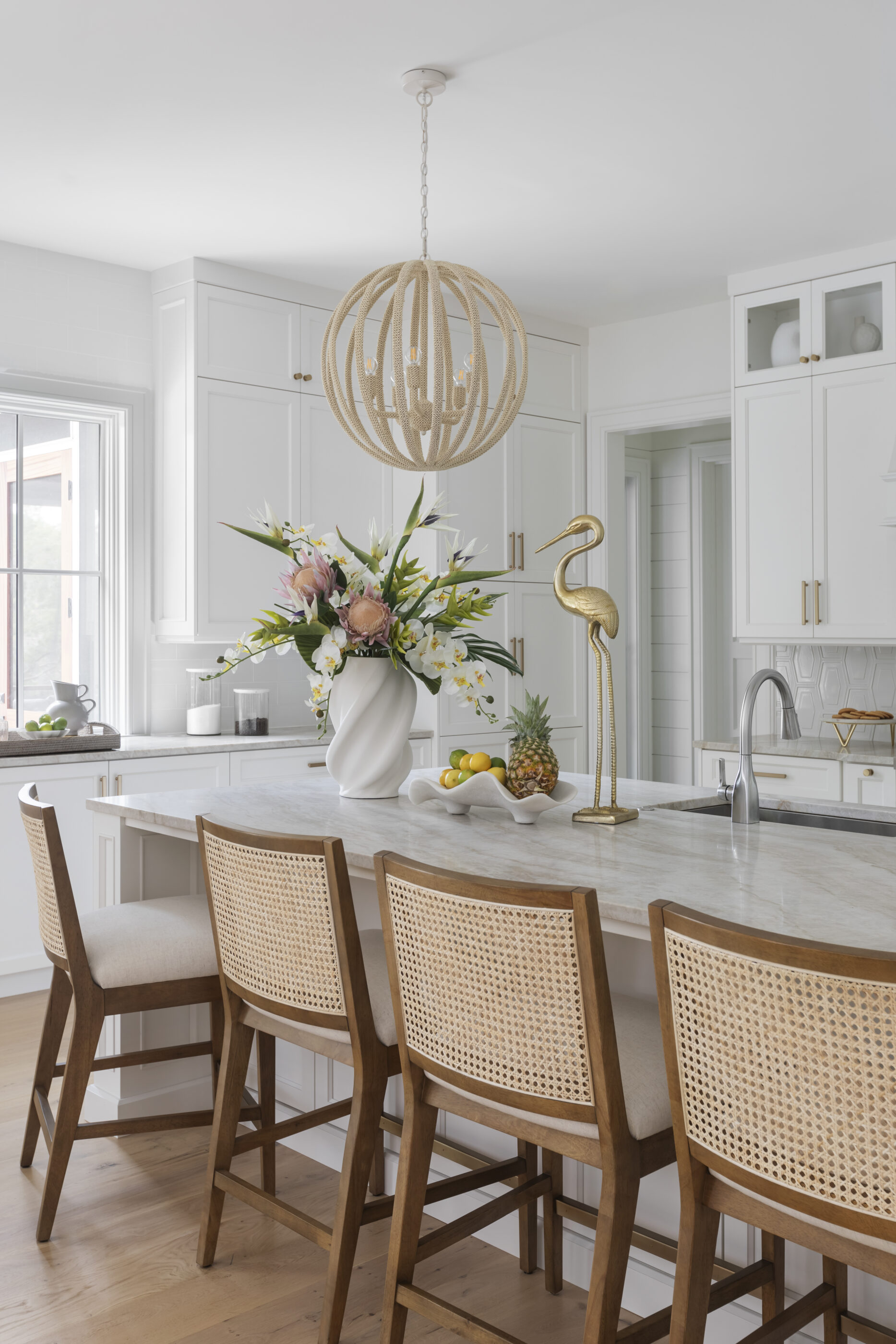 “Lowcountry luxury interior design by Megan Molten featuring coastal modern style, custom upholstery, woven textures, and statement lighting in a serene Kiawah home. Soft blues, neutrals, and sandy tones create an airy atmosphere across kitchen, living room, bedroom, bathroom, and poolside spaces