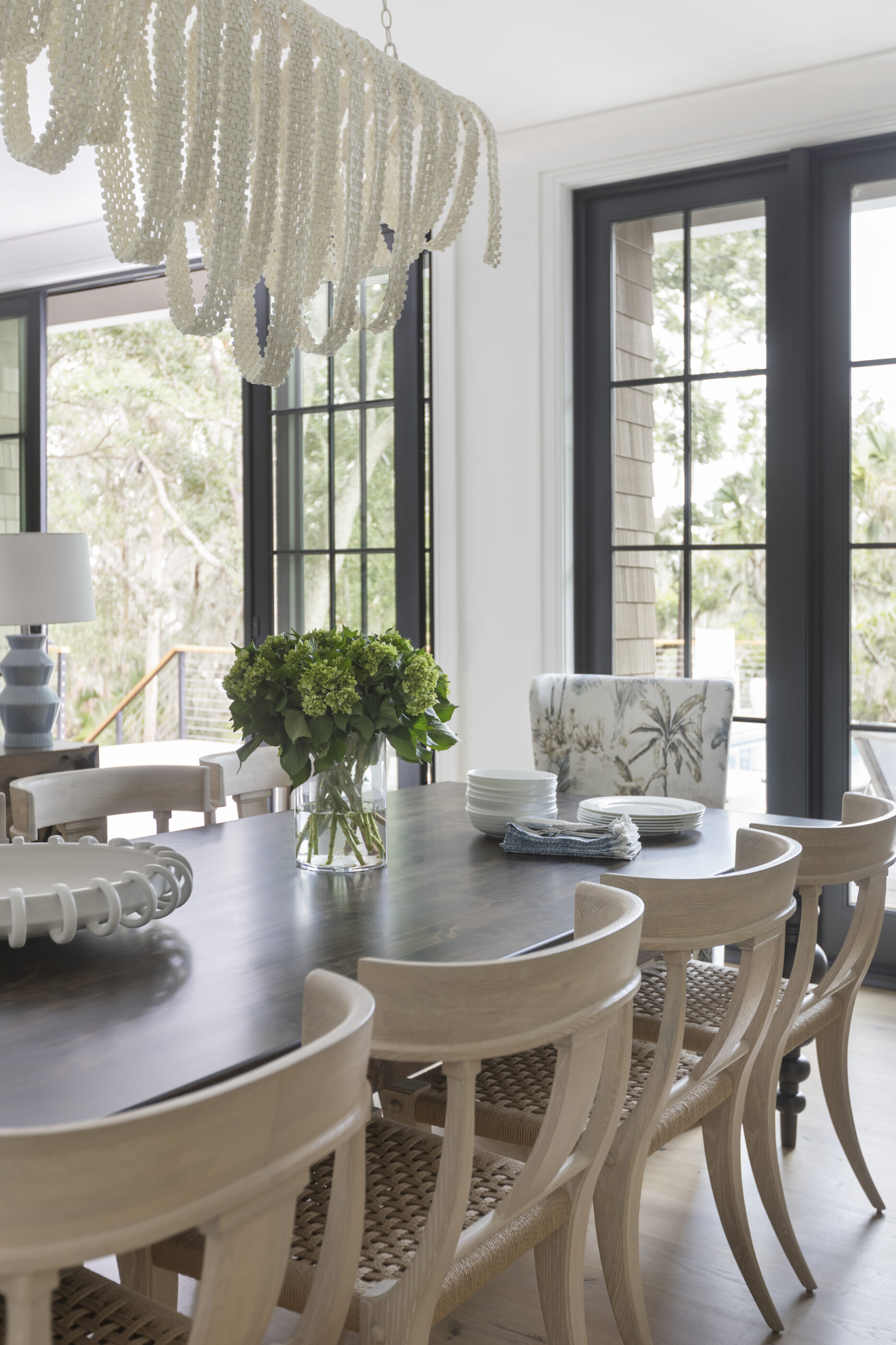 “Lowcountry luxury interior design by Megan Molten featuring coastal modern style, custom upholstery, woven textures, and statement lighting in a serene Kiawah home. Soft blues, neutrals, and sandy tones create an airy atmosphere across kitchen, living room, bedroom, bathroom, and poolside spaces