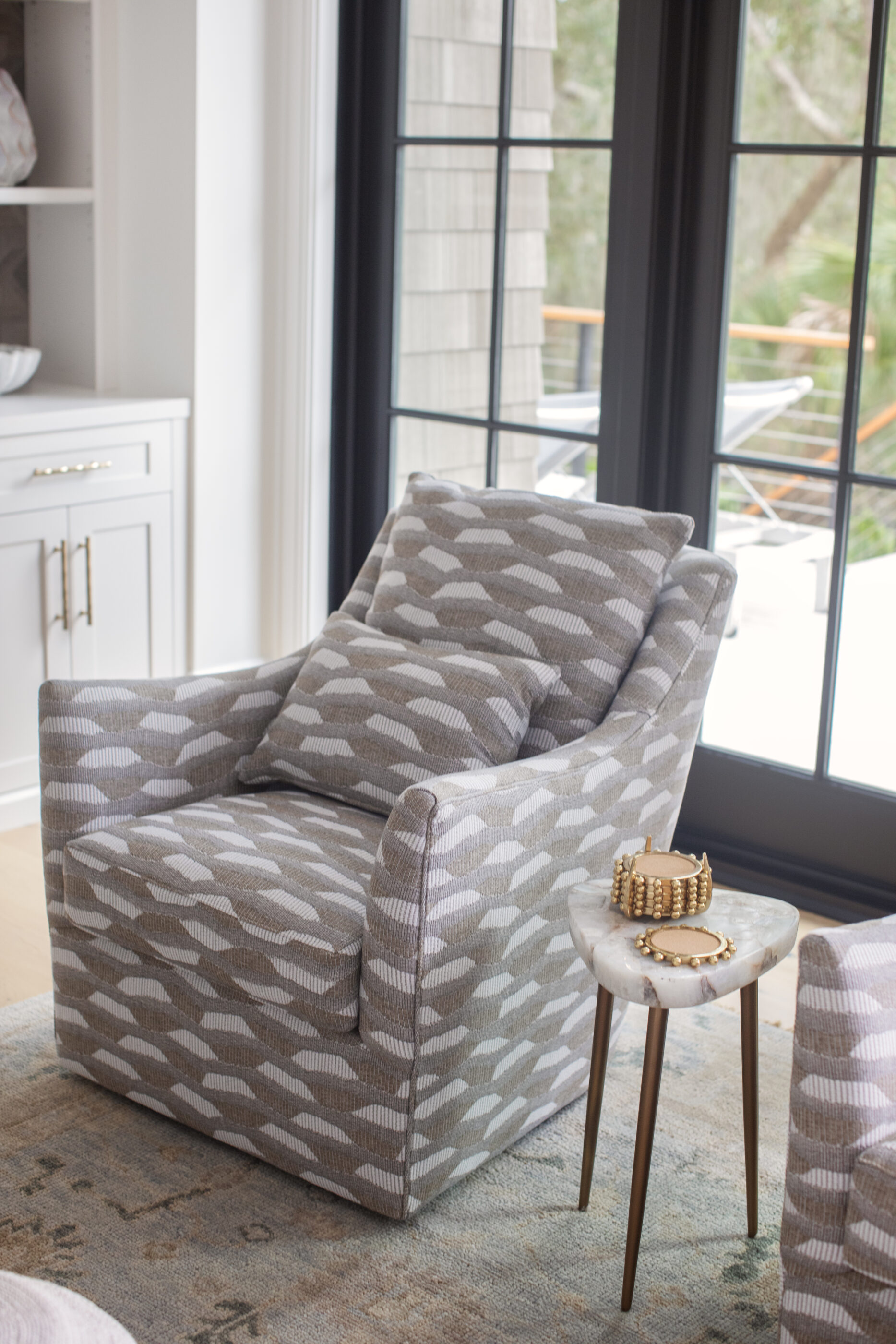 “Lowcountry luxury interior design by Megan Molten featuring coastal modern style, custom upholstery, woven textures, and statement lighting in a serene Kiawah home. Soft blues, neutrals, and sandy tones create an airy atmosphere across kitchen, living room, bedroom, bathroom, and poolside spaces