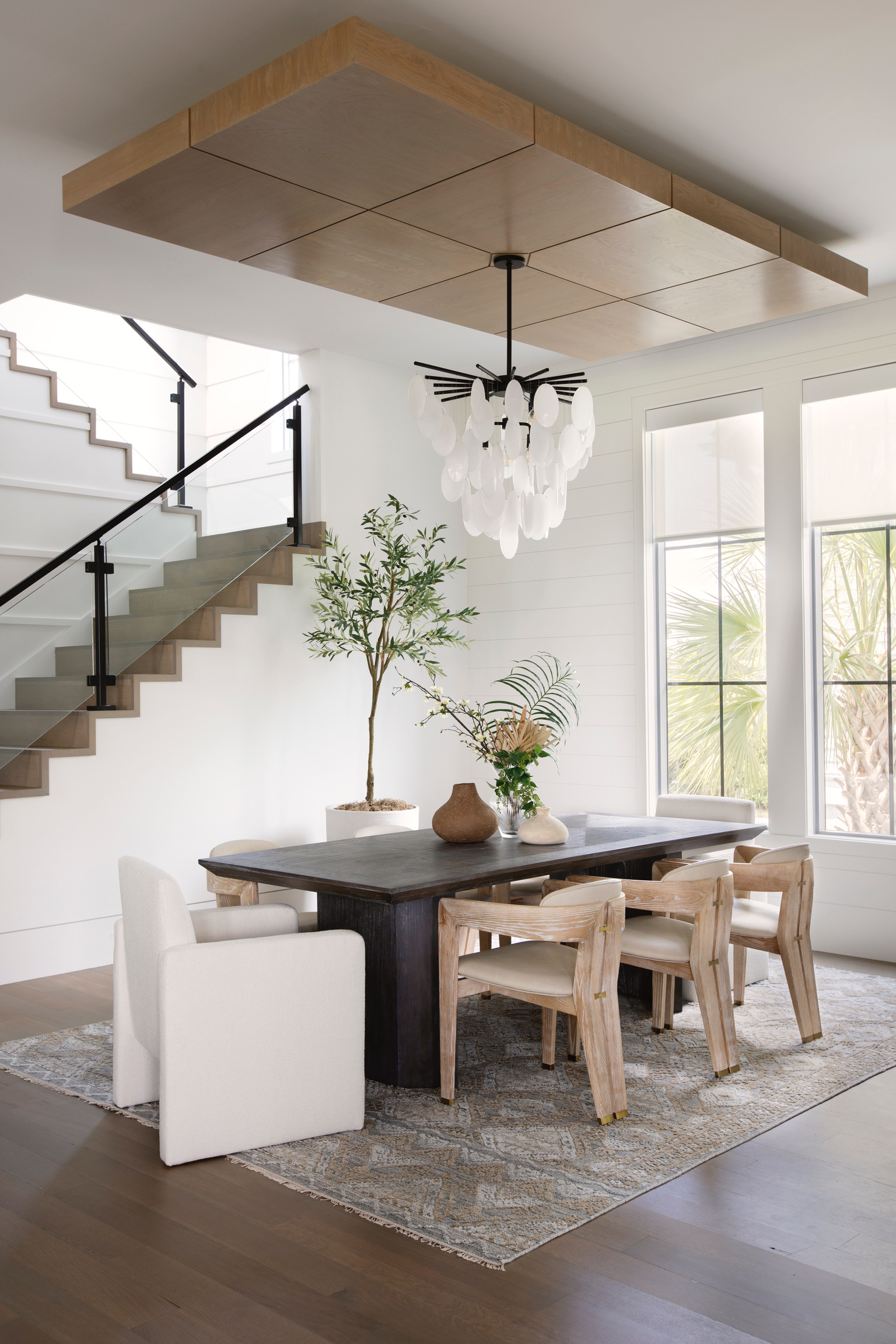 Elegant dining room with wood ceiling detail, statement chandelier, and natural textures for a high-end resort-inspired interior