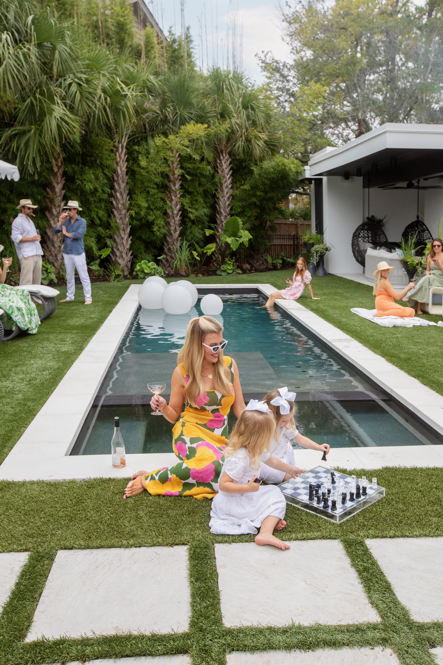 Charleston backyard pool party with stylish outdoor lounge furniture, tropical landscaping, and family-friendly luxury outdoor living space.