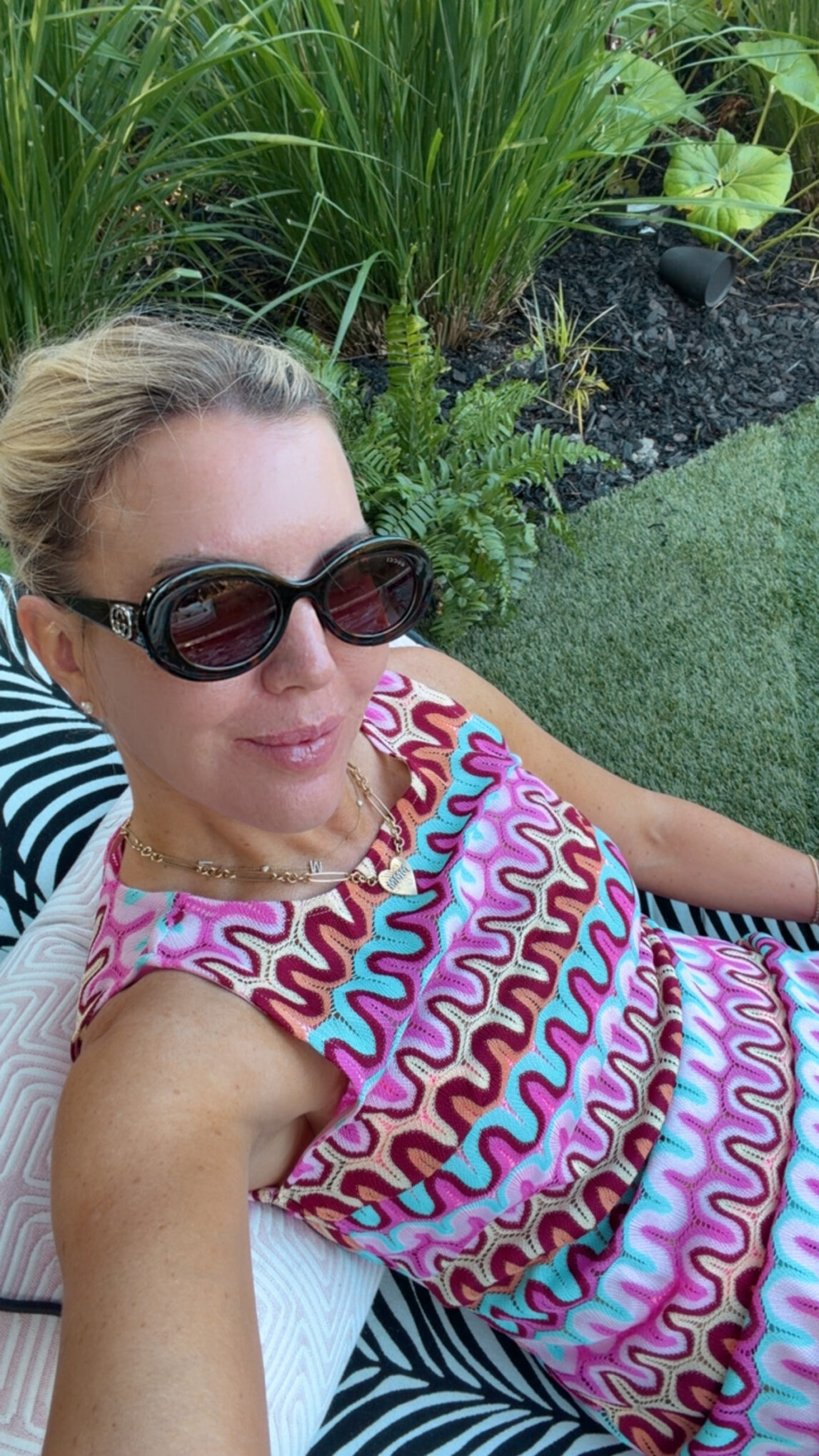 Megan Molten wearing a colorful designer-inspired crochet cover-up with oversized sunglasses for a chic summer vacation look.