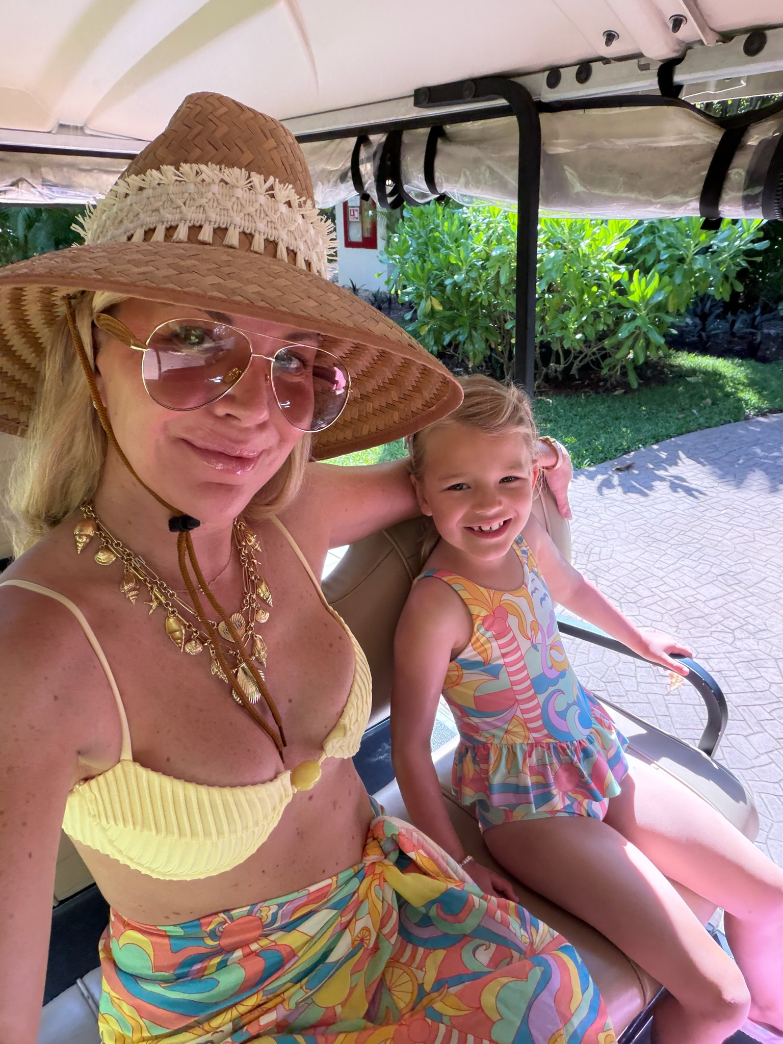 Megan Molten wearing gold designer-inspired sunglasses, layered gold jewelry, and a straw hat for a resort-style summer look.