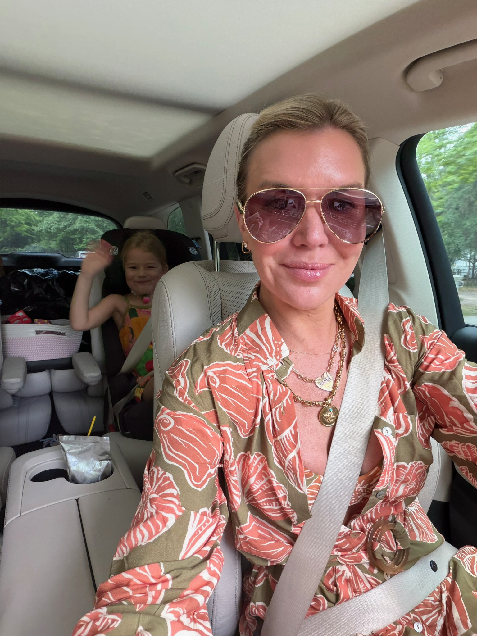 Megan Molten wearing retro gold designer-inspired sunglasses with a printed summer outfit.