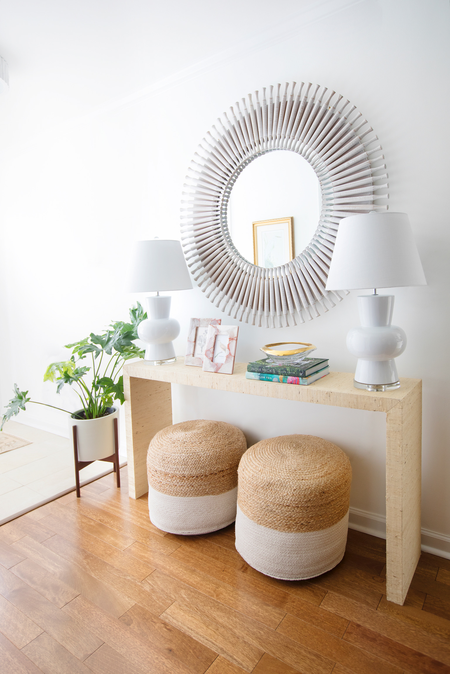 Bright coastal entryway with woven ottomans, white table lamps, greenery, and a statement mirror, inspired by relaxed Georgia coastal style.