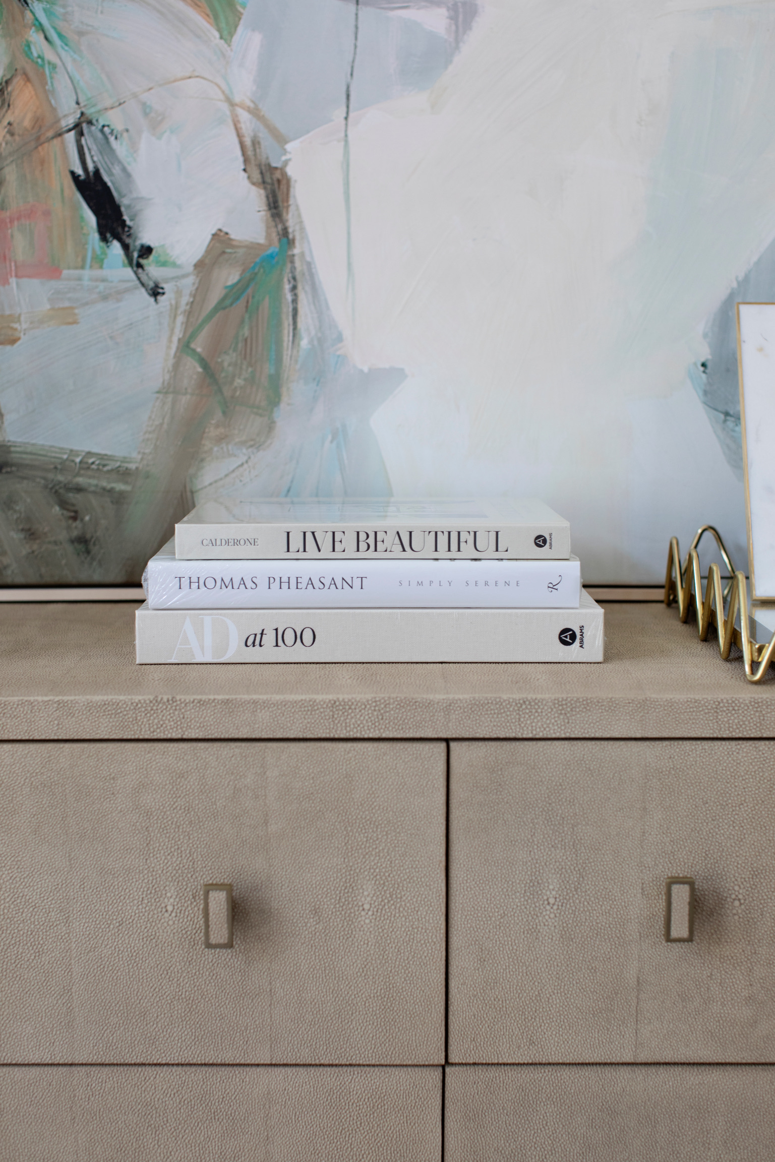 Stylish dorm room accessories with decorative boxes, candle, white vases, and gold accents