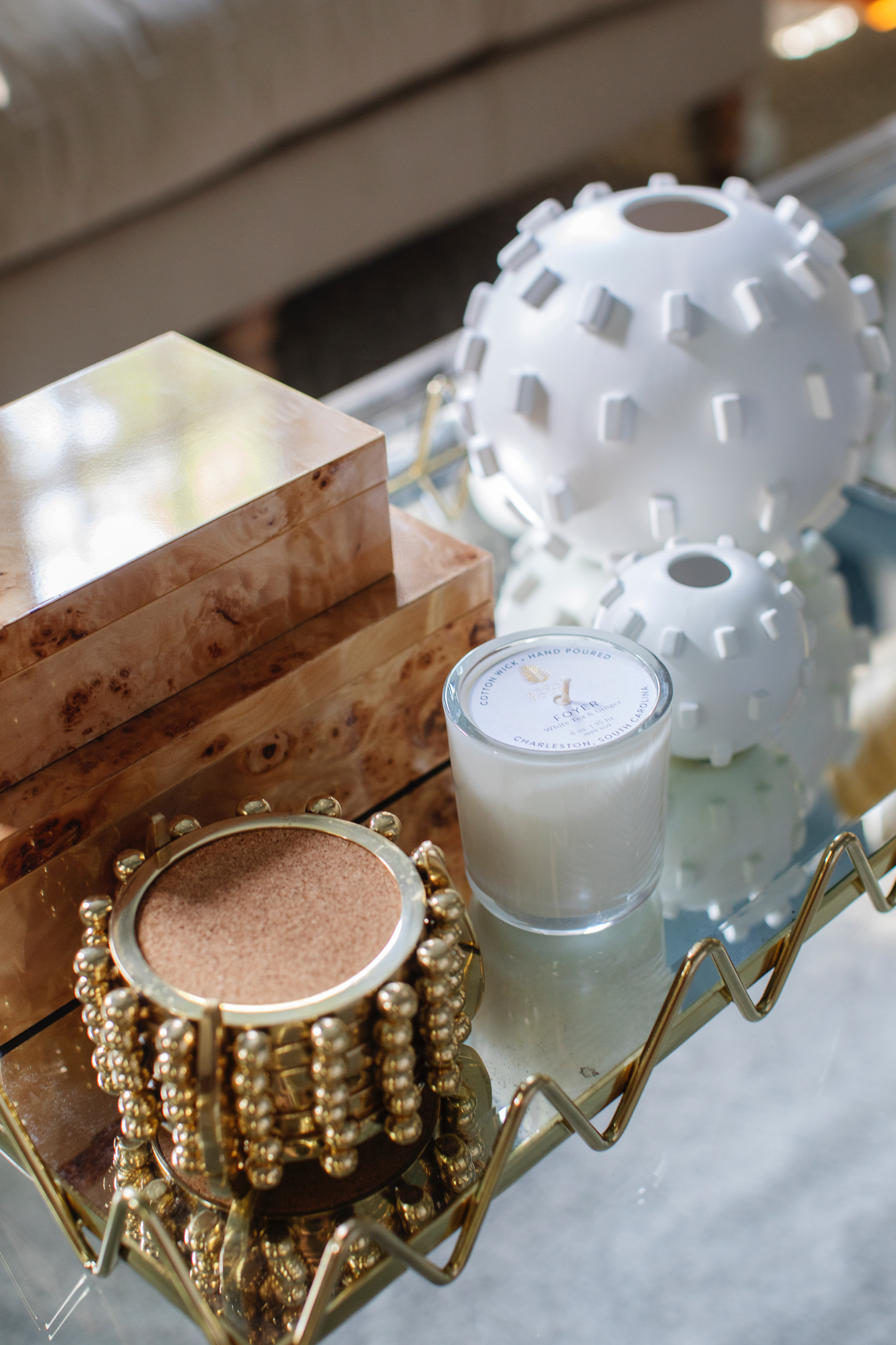 College dorm decor inspiration with stacked design books, abstract wall art, and gold decorative accents